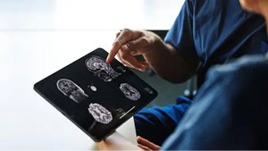 Stock Photo Of Two People Looking At Brain Scans On An Ipad